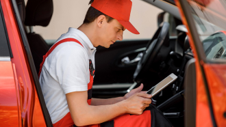 Mecânico dentro de carro a ver informações num tablet