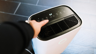 Homem a ligar desumidificador branco.